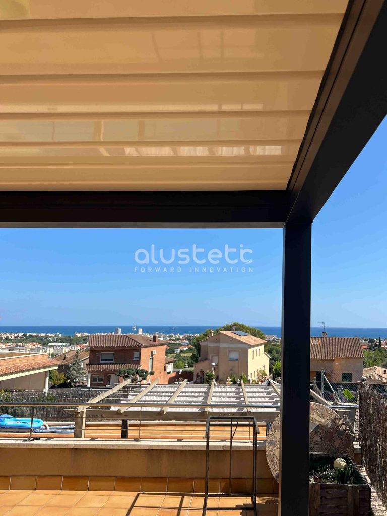 Pérgola bioclimática orientable con la estructura de color antracita y lamas color blanco