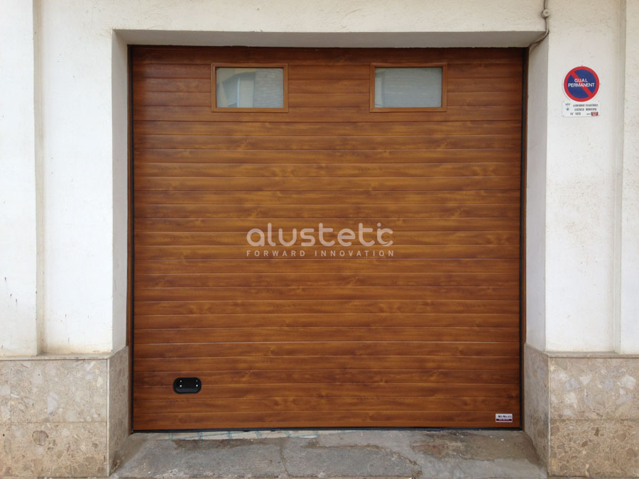 Puerta seccional integrada en la fachada de una vivienda