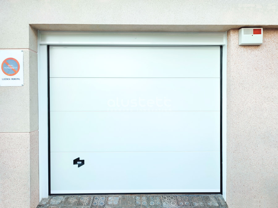 Puerta seccional blanca instalada en una vivienda