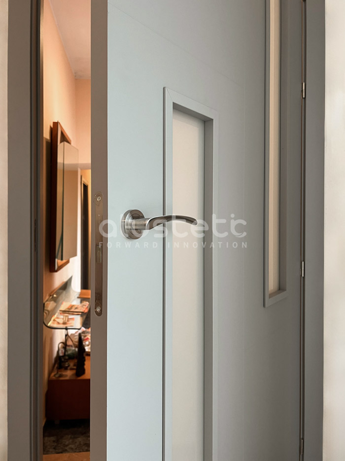 Detall de porta interior d'alumini gris amb vidre