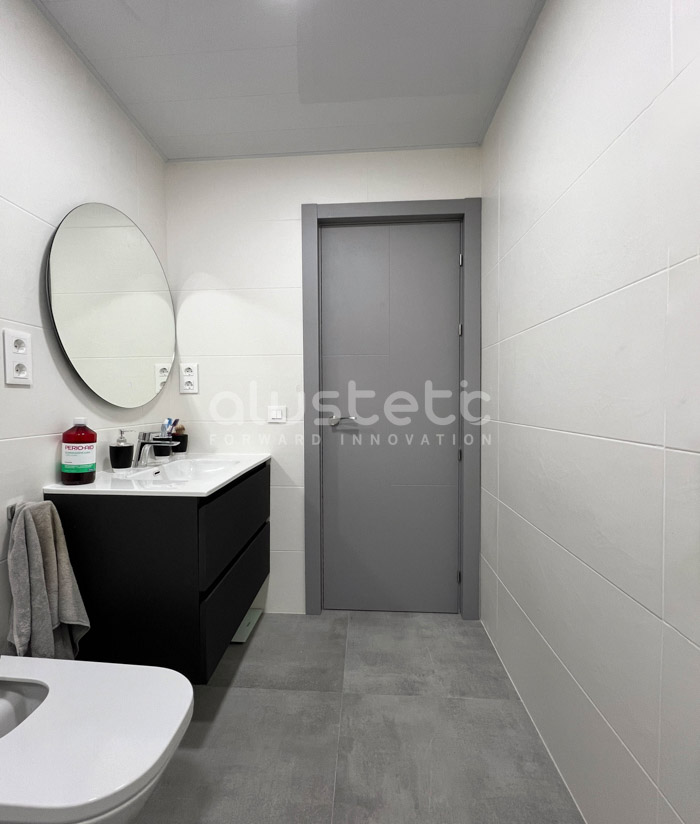 Porta interior d'alumini gris instal·lada al bany