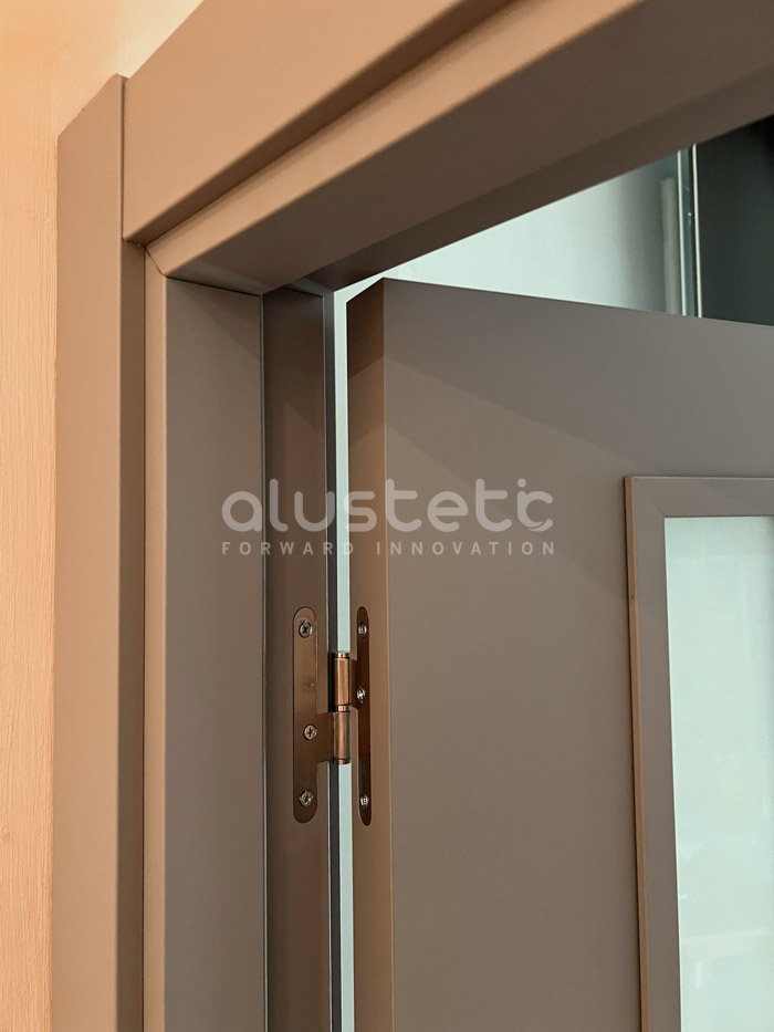 Detall de la frontissa d'una porta interior d'alumini