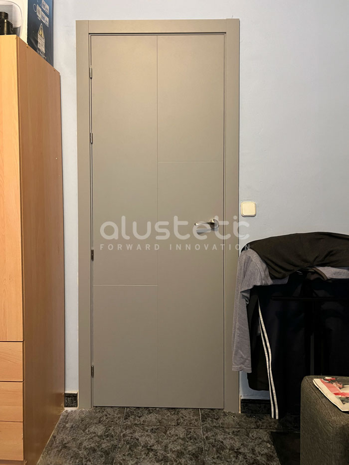 Porta interior d'alumini gris instal·lada en una habitació